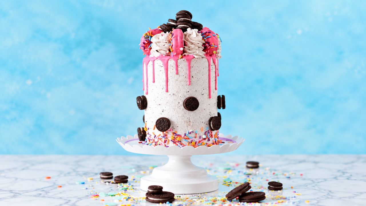 A chocolate layer cake finished with piped rosettes and a ganache drip.
